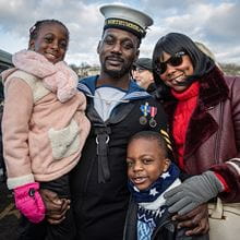 A Sailor of HMS Northumberland standing with his family after returning from deployment