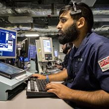 Royal Navy sailor works at computer in Operations Room