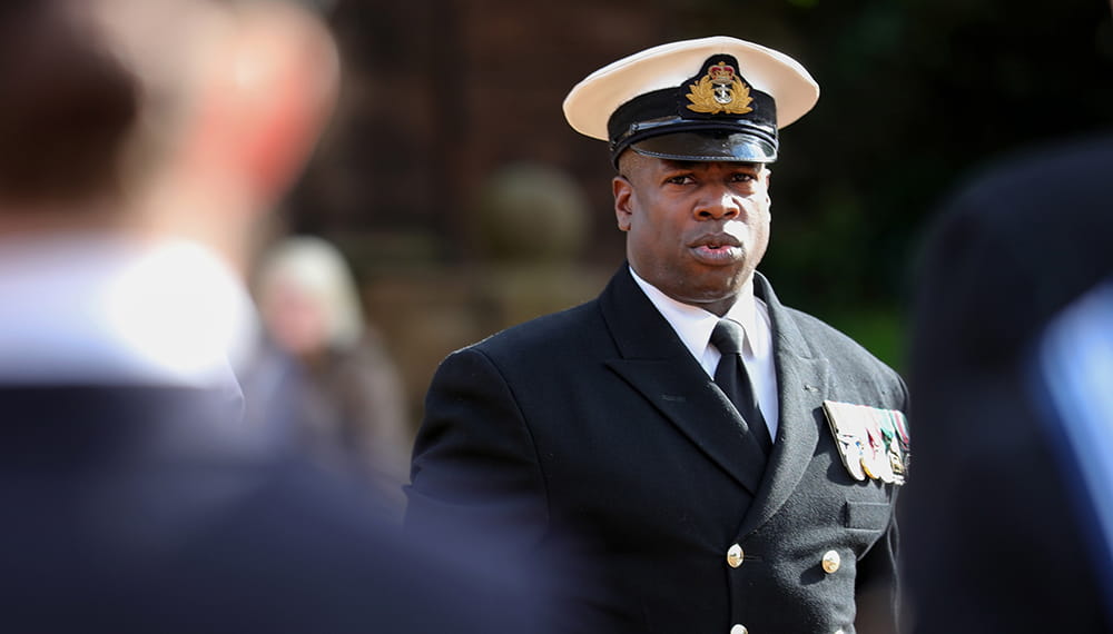 Royal Navy officer wearing dress uniform on parade looking towards the camera