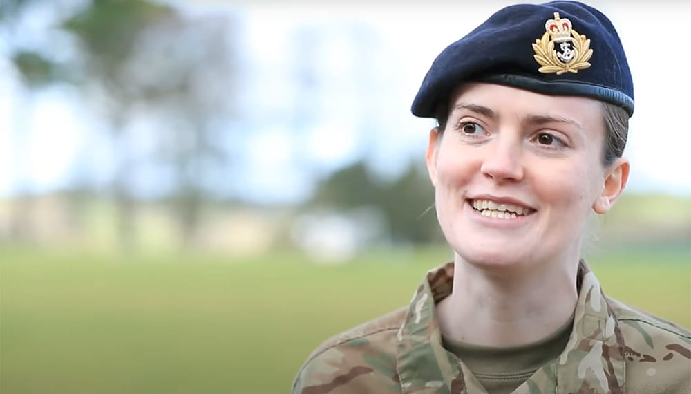 Close-up of a Royal Navy reservist wearing a cameo uniform and a blue beret during a video interview
