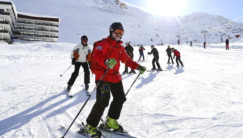 Petty Officer wearing a red ski jacket leads his class of beginners down the slope skiing during Alpine Championships
