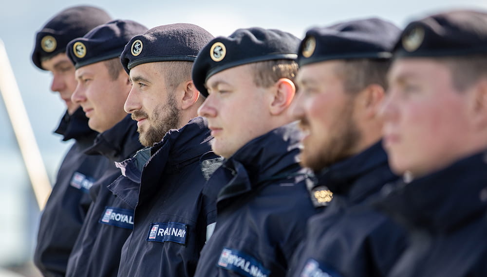 Royal Navy sailors wearing blue berets standing in a line-up