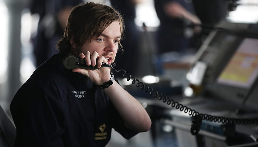  Royal Navy personnel working speaking on a phone and appears to be in a control room.