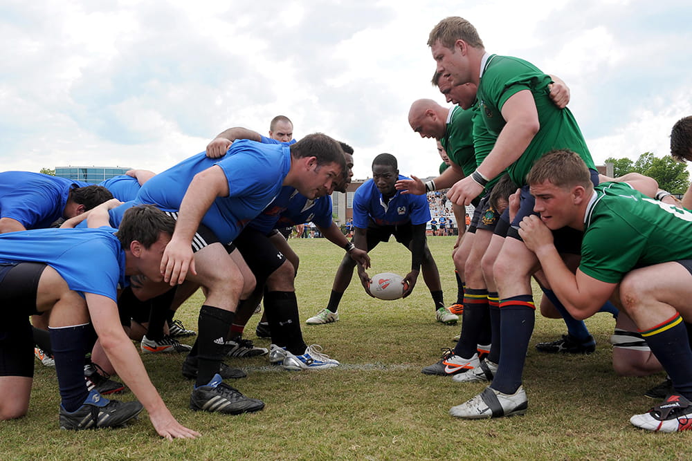 Two groups of people play a rugby match