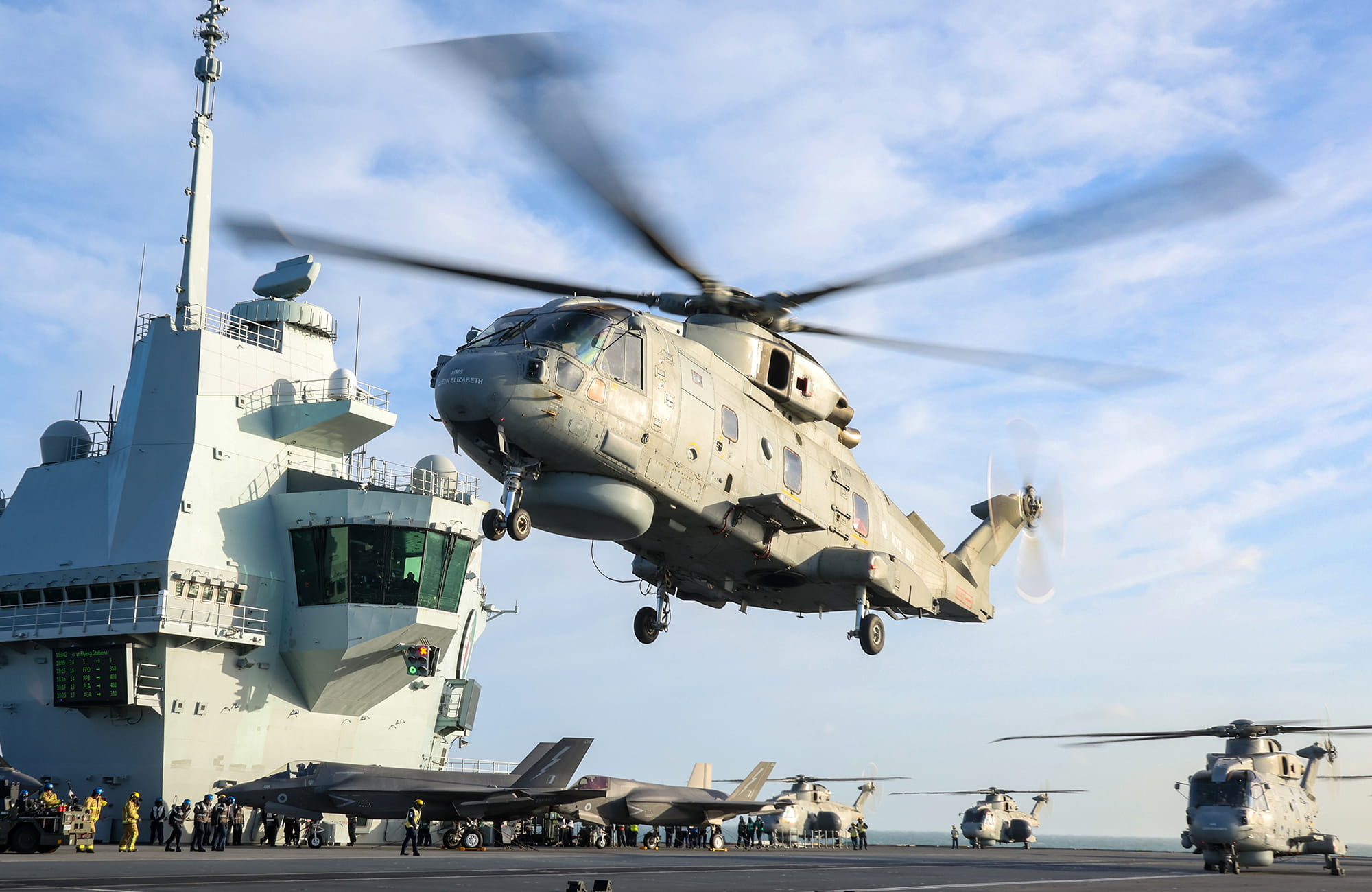 Merlin helicopter flying above the deck of an aircraft carrier