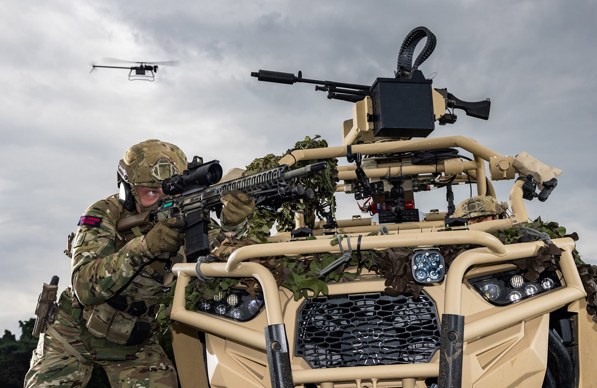 Royal Marine of 40 Commando taking aim behind a Polaris with drone in the background