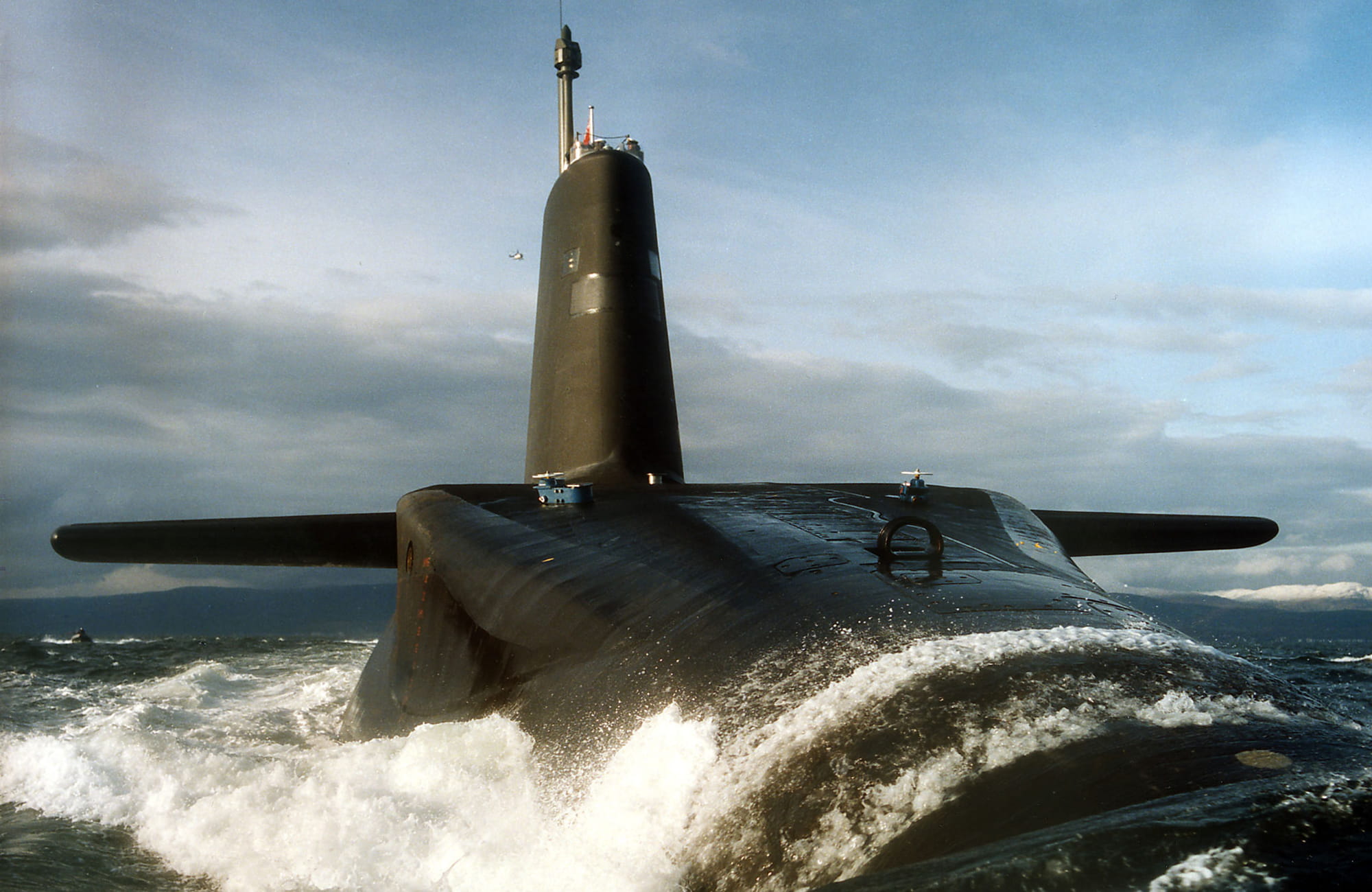 Massive Trident submarine surfaces with water pouring over its surface