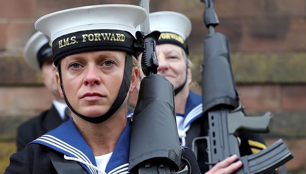 Royal Navy sailor holding gun on her shoulder
