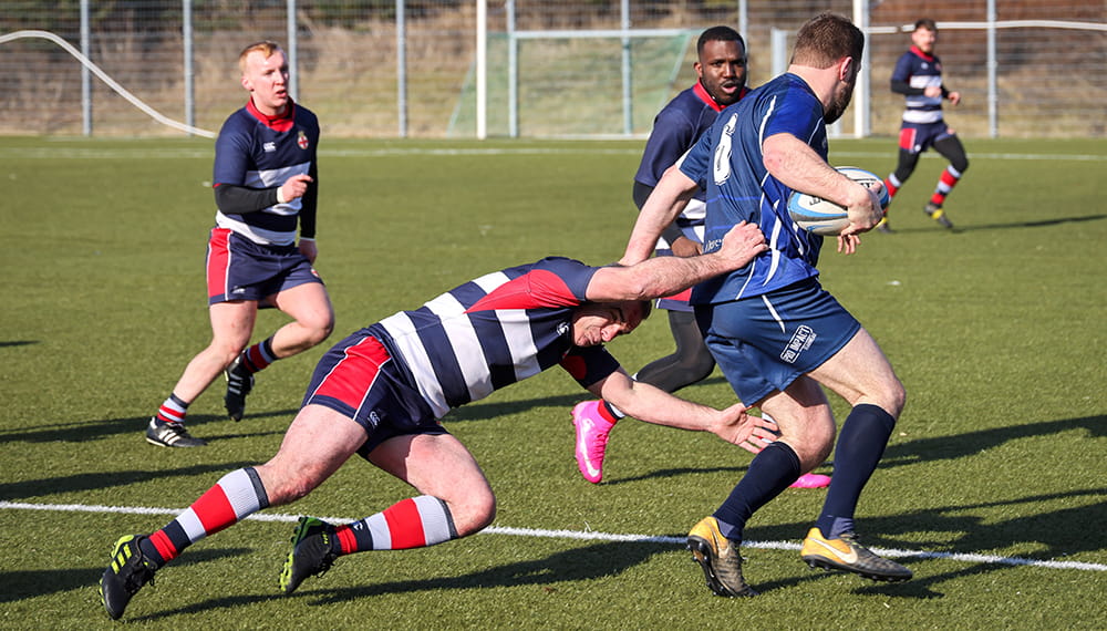 One man attempts to tackle another in a rugby match