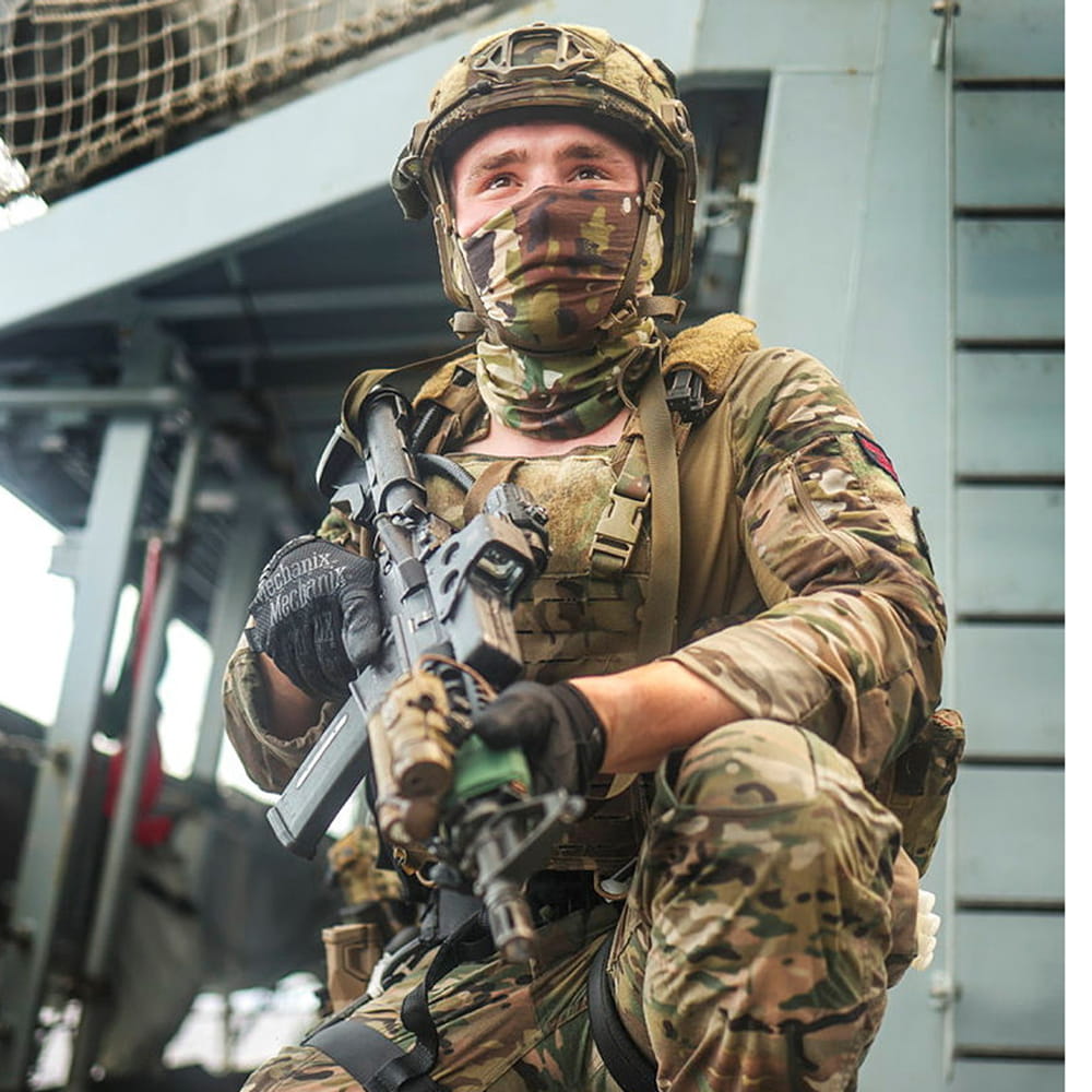 Royal Marine commando on one knee, guards a ship